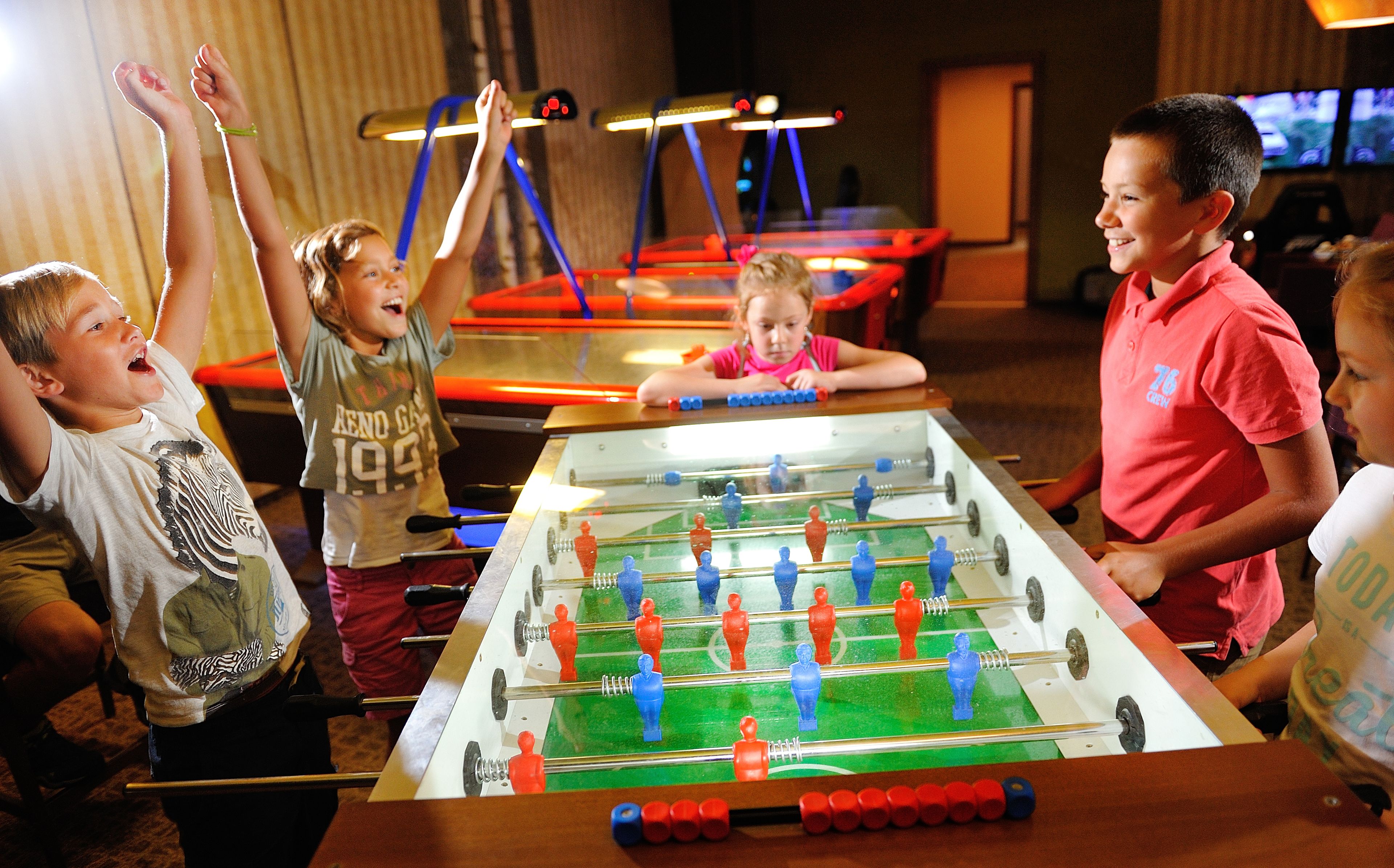 A group of children playing foosball.