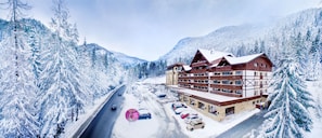 Ein mehrstöckiges Hotel mit Skipiste im Hintergrund.