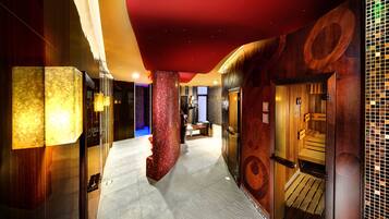 A modern hotel corridor with a red ceiling, wooden paneling, and a mosaic wall.