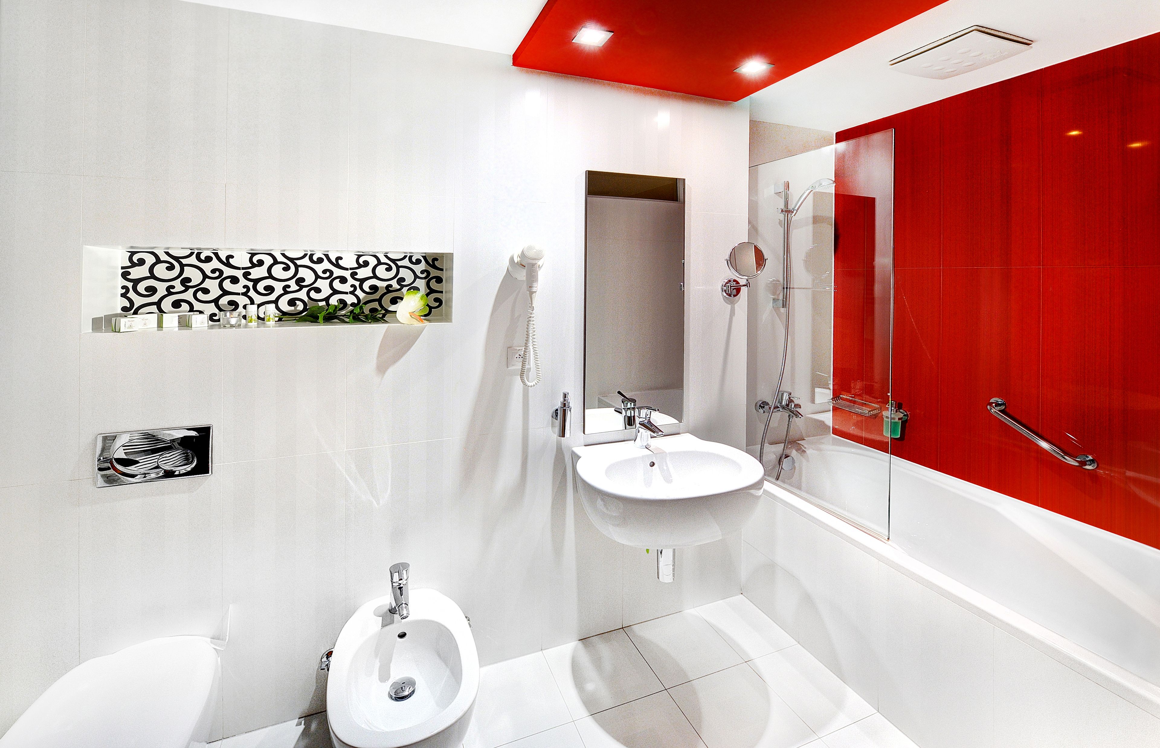 A modern bathroom with a white toilet, bidet, and a large bathtub.