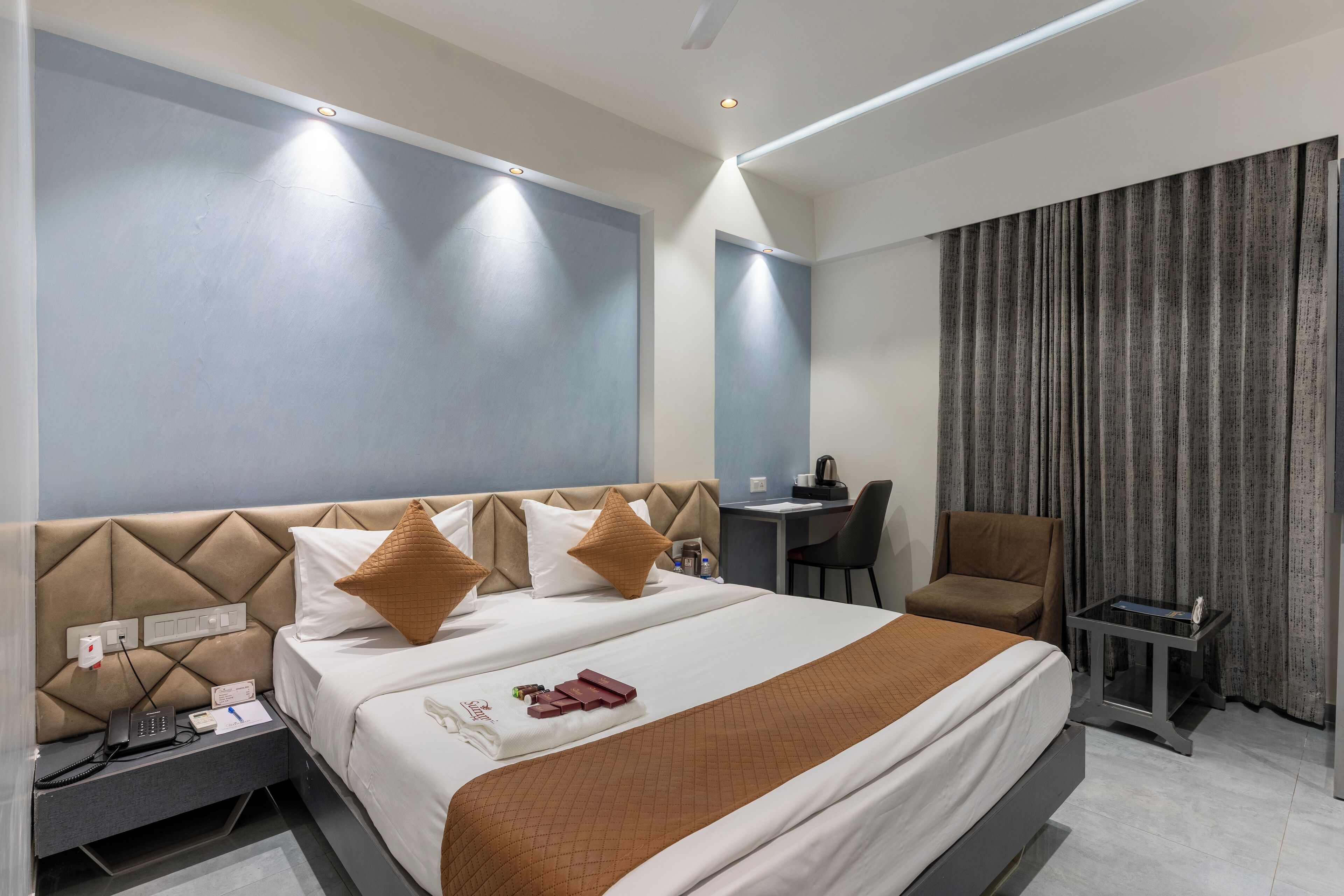 Een moderne hotelkamer met een groot bed, een bureau en een stoel.