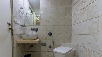 A bathroom with a white sink, mirror, and toilet.