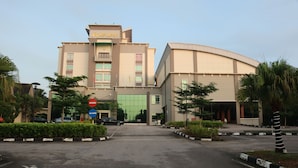 A modern building with a curved facade, multiple windows, and a sign indicating a hotel.