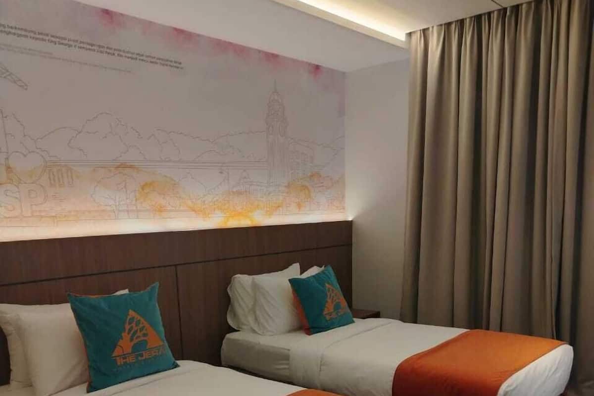 Ein Hotelzimmer mit zwei Betten, einer großen Wandmalerei und einem Vorhang.