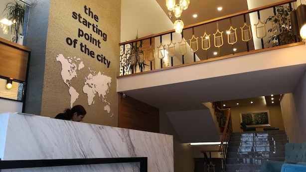 A hotel reception area with a marble counter, a world map, and a sign that reads "START OTEL". - Start Hotel (Antalya)