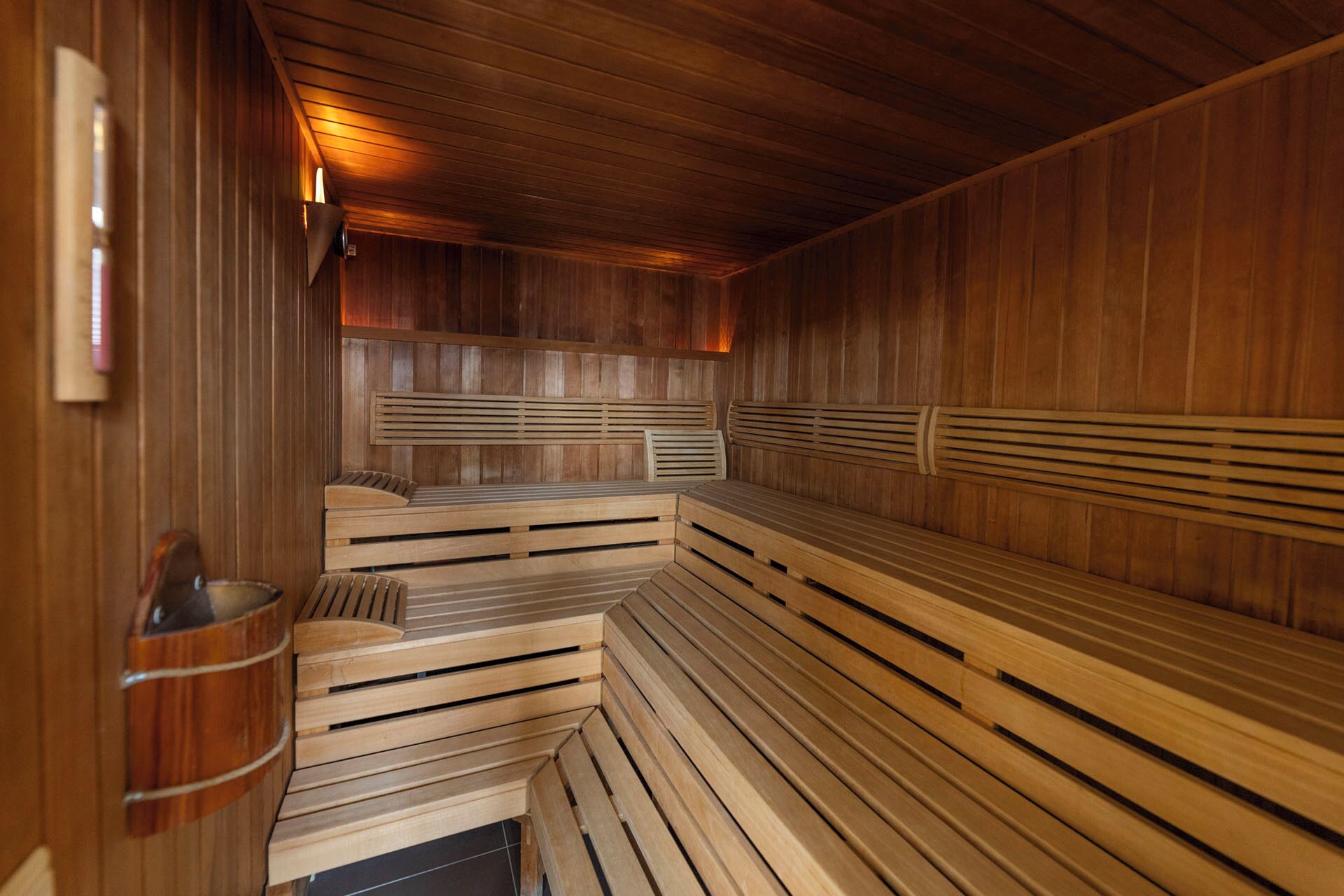 Un sauna doté de bancs en bois et d’un plancher à pente.