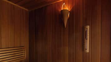 Una sala de sauna con bancos de madera y una lámpara fijada a la pared.