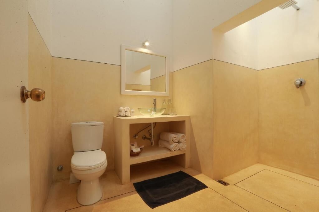Ein kleines Badezimmer mit Toilette, Waschbecken und Spiegel.