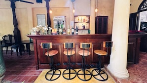 A bar area with a wooden counter, four stools, and a sign for 'Mango House Restaurant'. - Mango House (Galle)