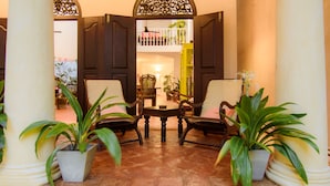 A traditional interior with a central table and chairs, surrounded by potted plants. - Mango House (Galle)