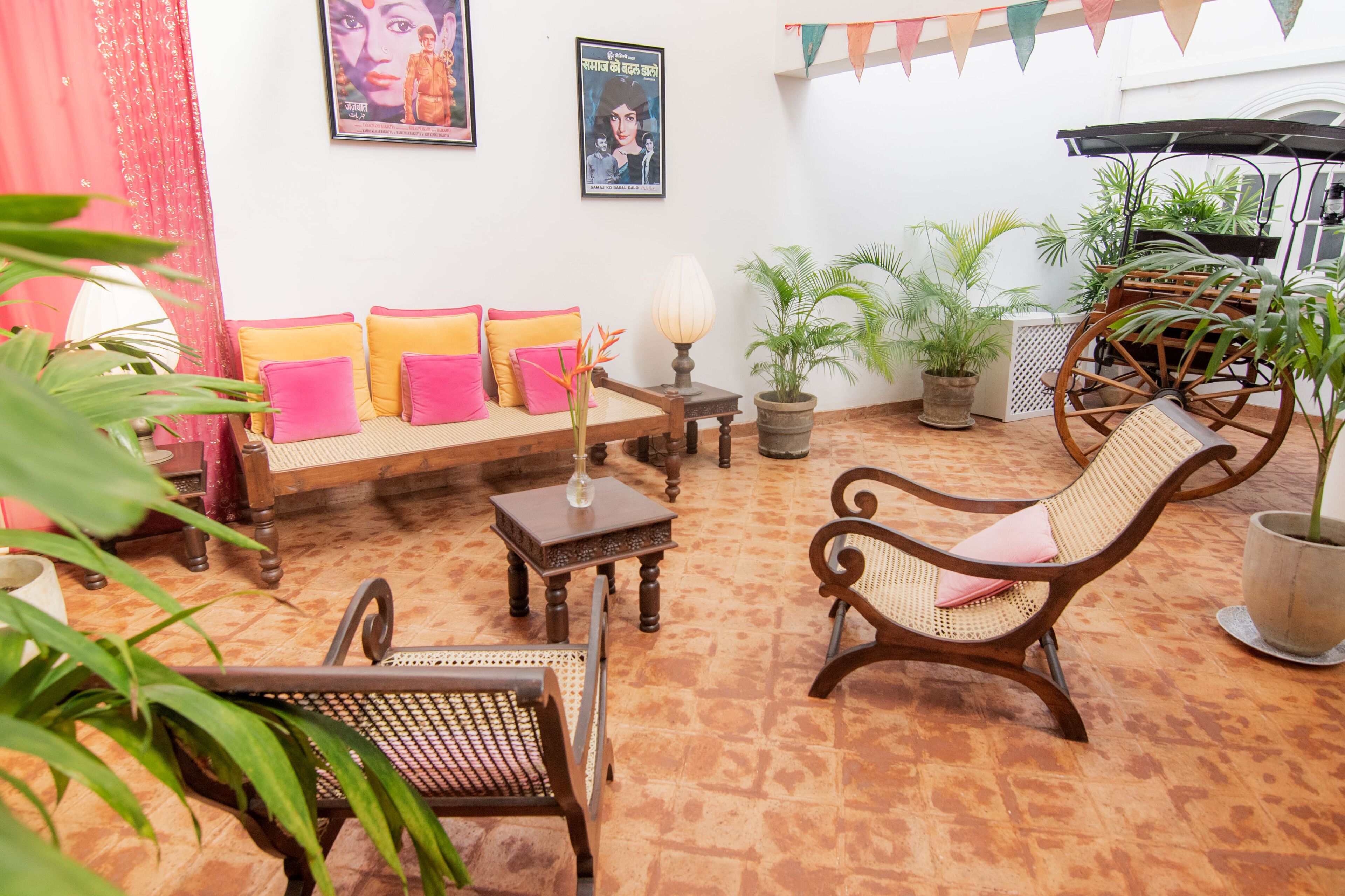 A cozy living area with a sofa, chairs, a table, and potted plants.