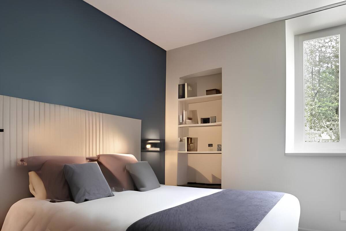 Een moderne slaapkamer met een bed, nachtkastjes en een inbouwkast.