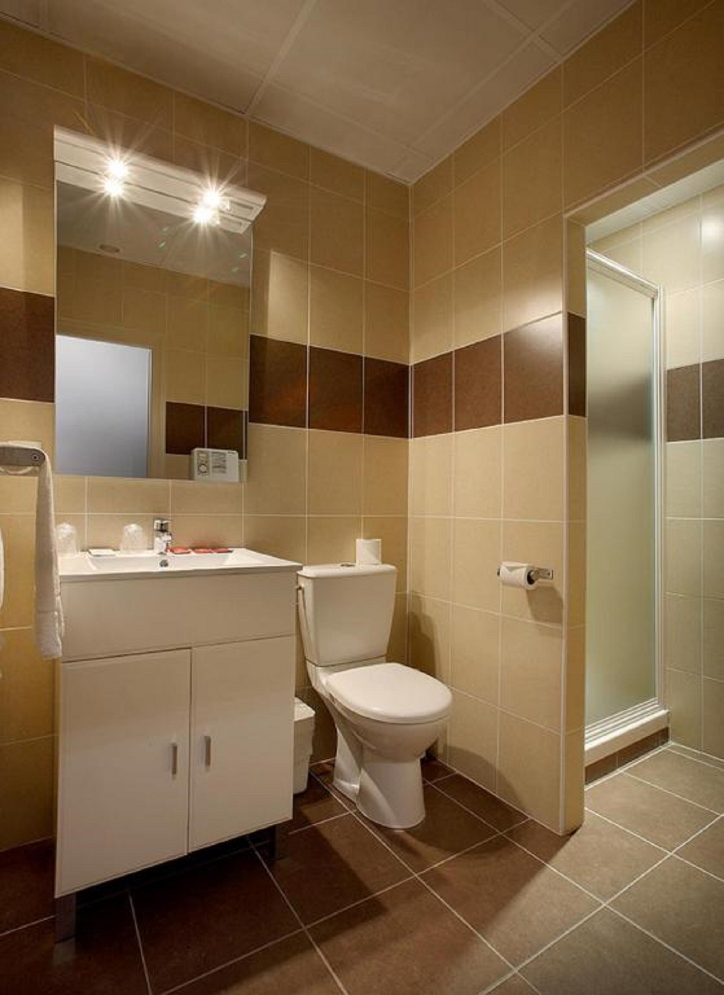 Une salle de bain avec des toilettes, un lavabo et un miroir.