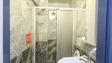 A bathroom with a shower, a sink, and a mirror.