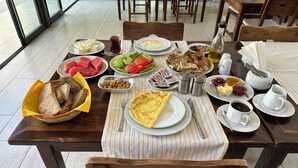 Un tavolo imbandito per la colazione, con pane, uova e verdure.