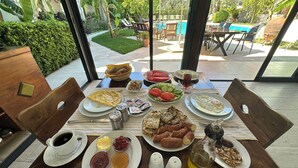 Un tavolo da pranzo con diversi piatti, una tazza di caffè e salse.