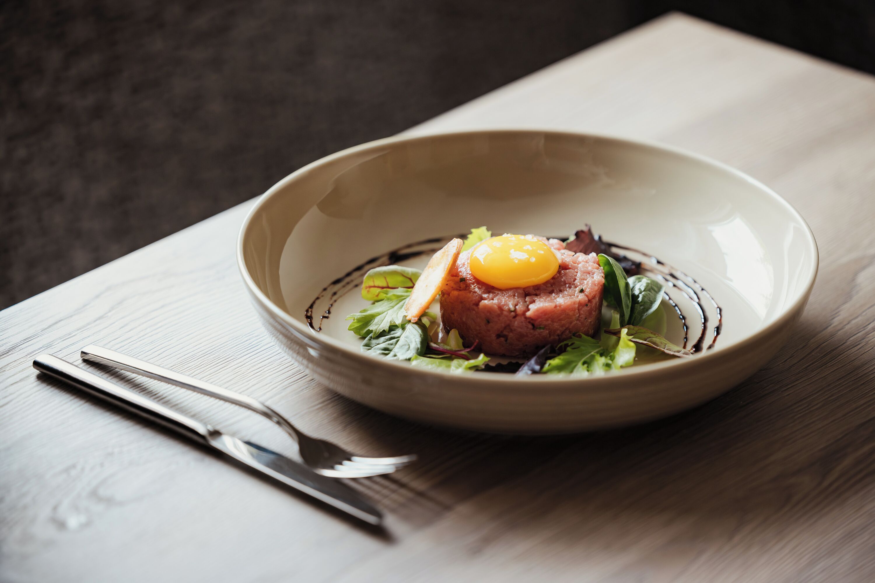 A plate of food with a knife and fork beside it.