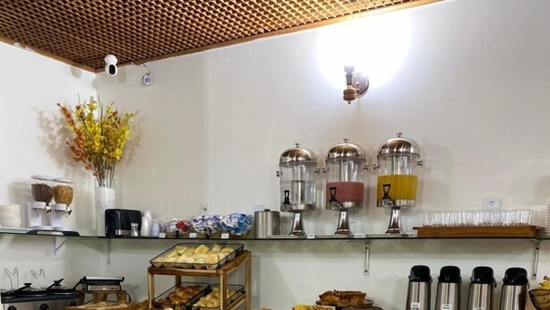 A hotel breakfast area with a buffet setup, including various food items and condiments. - Max Hotel (Nucleo Bandeirante)