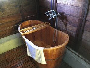 A wooden bathtub with a showerhead and a wooden tray. - Tanabendang Banglos (Langkawi)