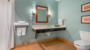 A bathroom with a sink, mirror, towel rack, toilet, and shower curtain.