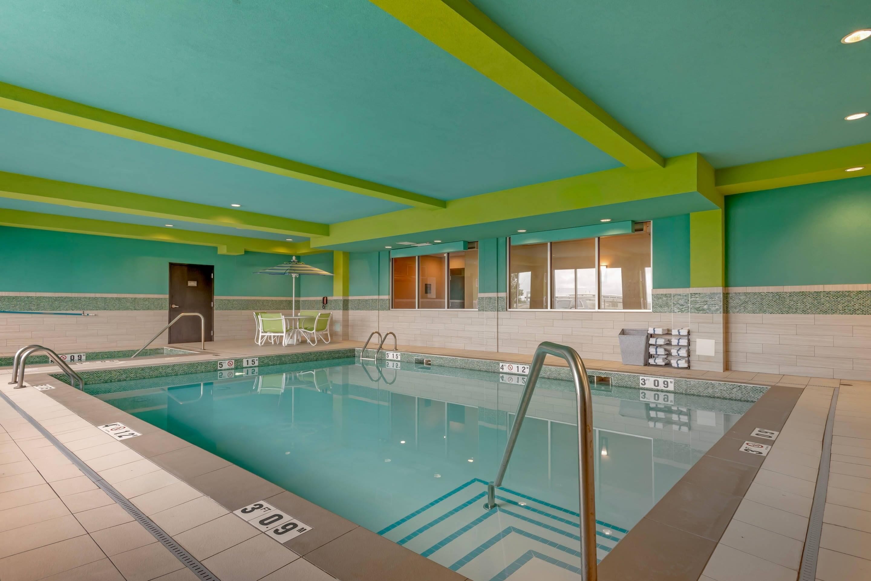 A swimming pool with clear lane markings, a changing room, and a door leading to another area.