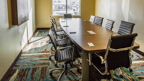 A conference room with a long table, six chairs, and a large window. - Comfort Inn & Suites Airport North (Calgary)