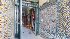 Une porte avec une pancarte « BIENVENUE », des carreaux décorés et un extincteur.