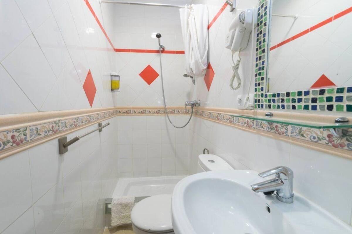 Un baño con ducha, inodoro y lavamanos.