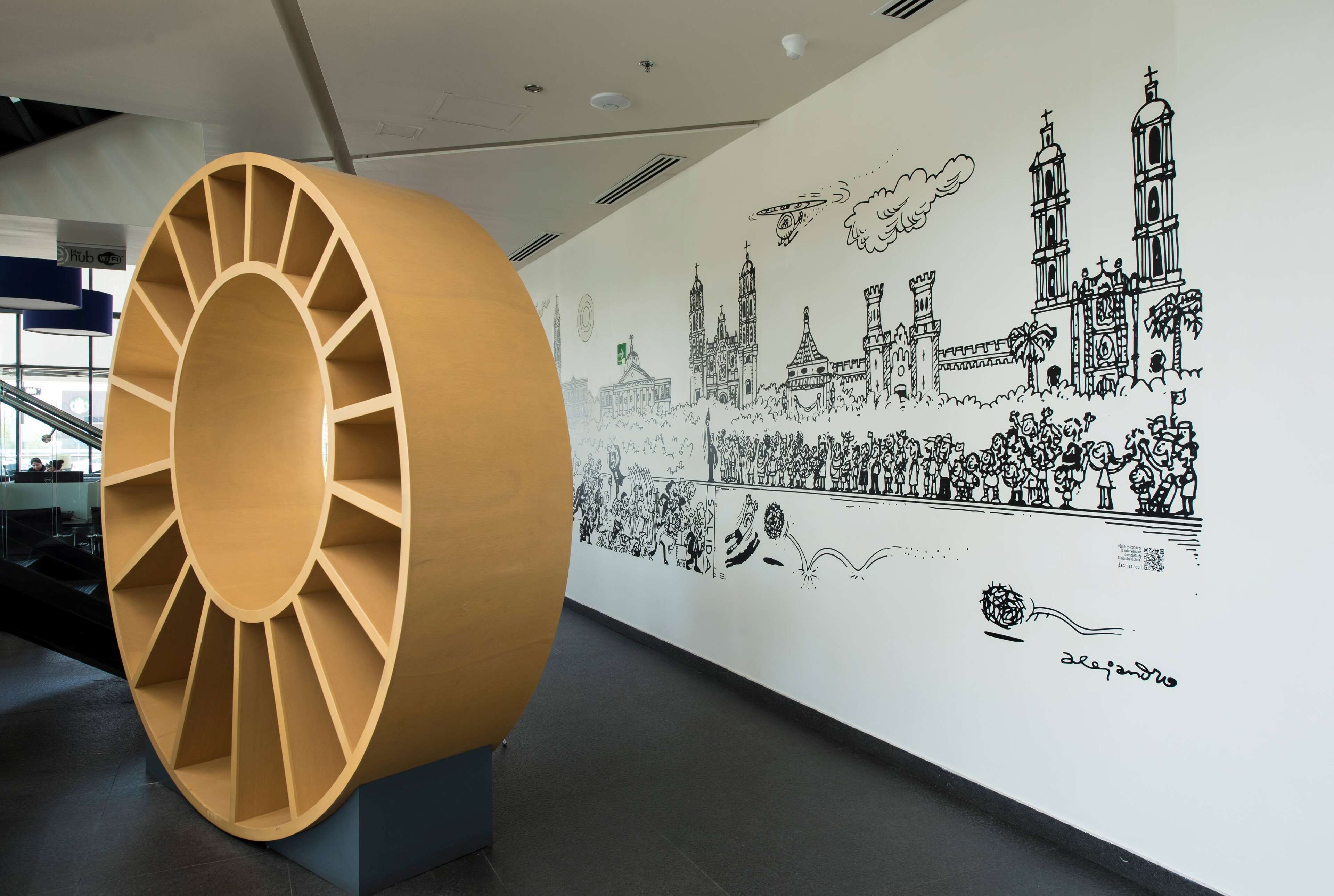 Une grande sculpture en bois de forme circulaire, une fresque représentant des bâtiments et des personnages historiques, et un code QR.