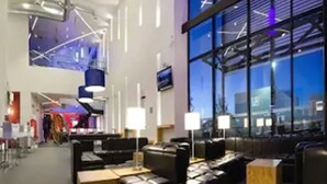 A modern hotel lobby with leather seating, large windows, and contemporary lighting fixtures. - Ramada Encore by Wyndham San Luis Potosi (San Luis Potosi)
