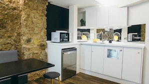 A modern kitchen with white cabinets, a built-in microwave, and a dishwasher. - Beautiful Belleville Hostel & Hotel (Paris)