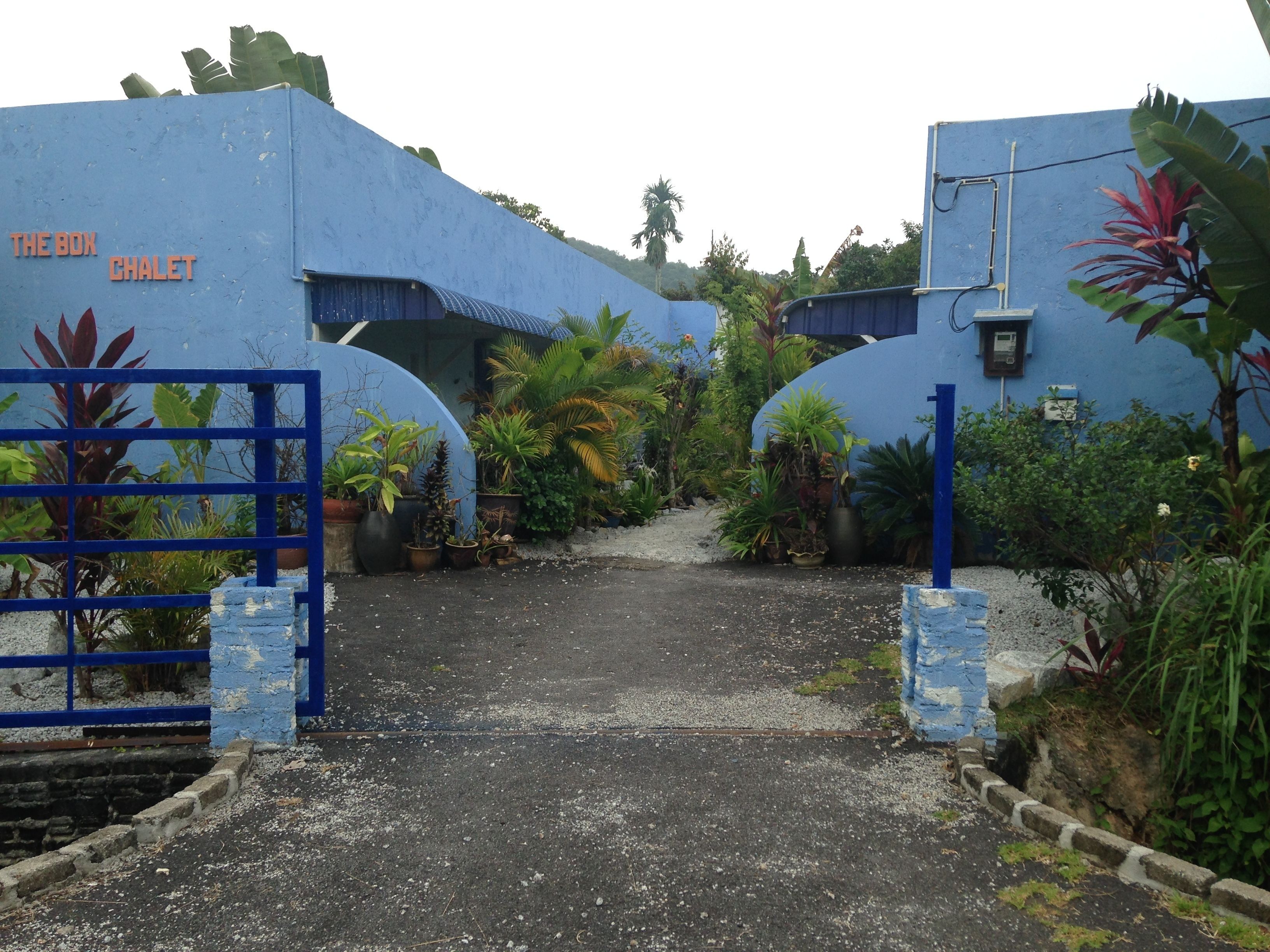 Una entrada cerrada con un muro azul y un letrero que dice "The Box Chalet".
