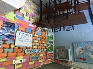 A colorful brick wall with a welcome sign, a map, and a staircase. - The Box Chalet (Langkawi)