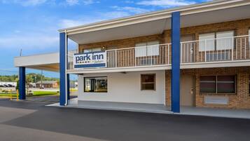 Ein zweigeschossiges Gebäude mit einem Schild für 'Park Inn by Radisson' im Erdgeschoss.