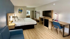 A hotel room with a bed, a desk with a computer, a TV, a chair, and a desk lamp. - Park Inn by Radisson, Weldon - Roanoke Rapids (Weldon)