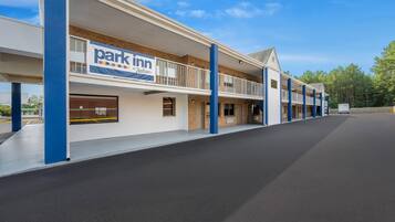 A multi-story parking structure with a 'Park Inn by Radisson' sign, featuring a flat roof and a series of balconies.