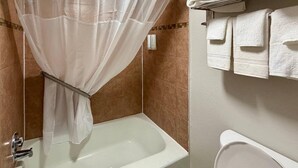 A bathroom with a bathtub, toilet, and shower curtain. - Park Inn by Radisson, Weldon - Roanoke Rapids (Weldon)