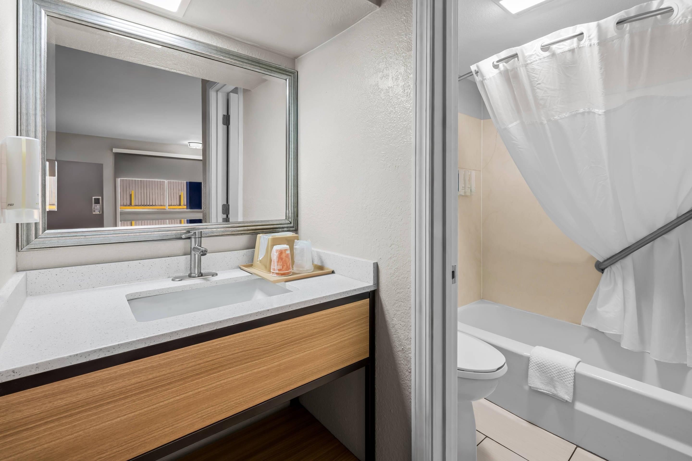 A modern bathroom with a sink, mirror, and shower.