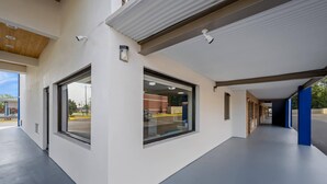 A modern building exterior with large windows, a covered walkway, and a visible street view. - Park Inn by Radisson, Weldon - Roanoke Rapids (Weldon)
