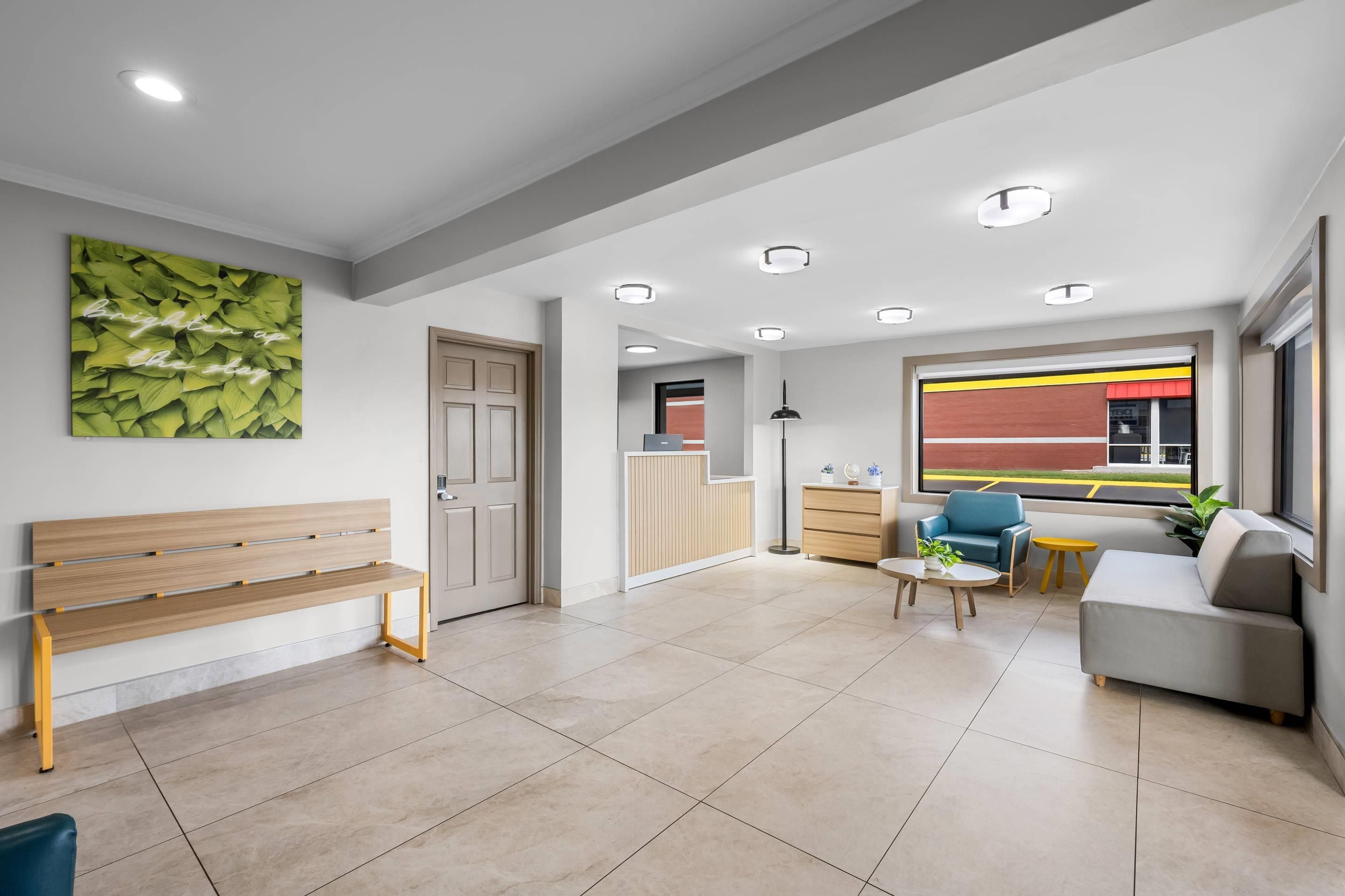 Un salon moderne avec un banc, un canapé, une table basse et une vue sur l’extérieur.