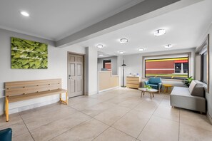 Uma sala de estar moderna com um banco, um sofá, uma mesa de centro e vista para o exterior.