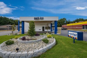 A park inn with a clear entrance, a landscaped garden, and a sign indicating the direction to the parking area. - Park Inn by Radisson, Weldon - Roanoke Rapids (Weldon)