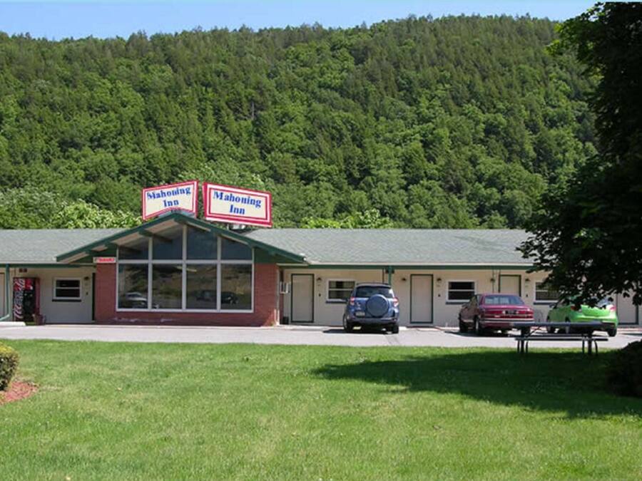 A two-story motel with a green roof and a signboard indicating it is a Mahoning Inn.