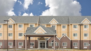 A multi-story hotel with a central entrance, large windows, and a flat roof.