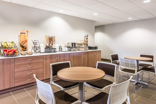 A breakfast area with a counter, seating, and a fruit display. - Microtel Inn & Suites By Wyndham Beaver Falls (Beaver Falls)