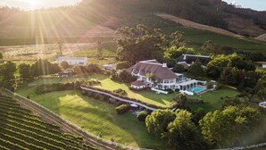 A large estate with multiple buildings, expansive lawns, and vineyard rows. - Mont Rochelle Hotel & Vineyard (Franschhoek)