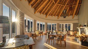 A spacious dining area with high ceilings and large windows, providing ample natural light and views of the outdoors. - Mont Rochelle Hotel & Vineyard (Franschhoek)