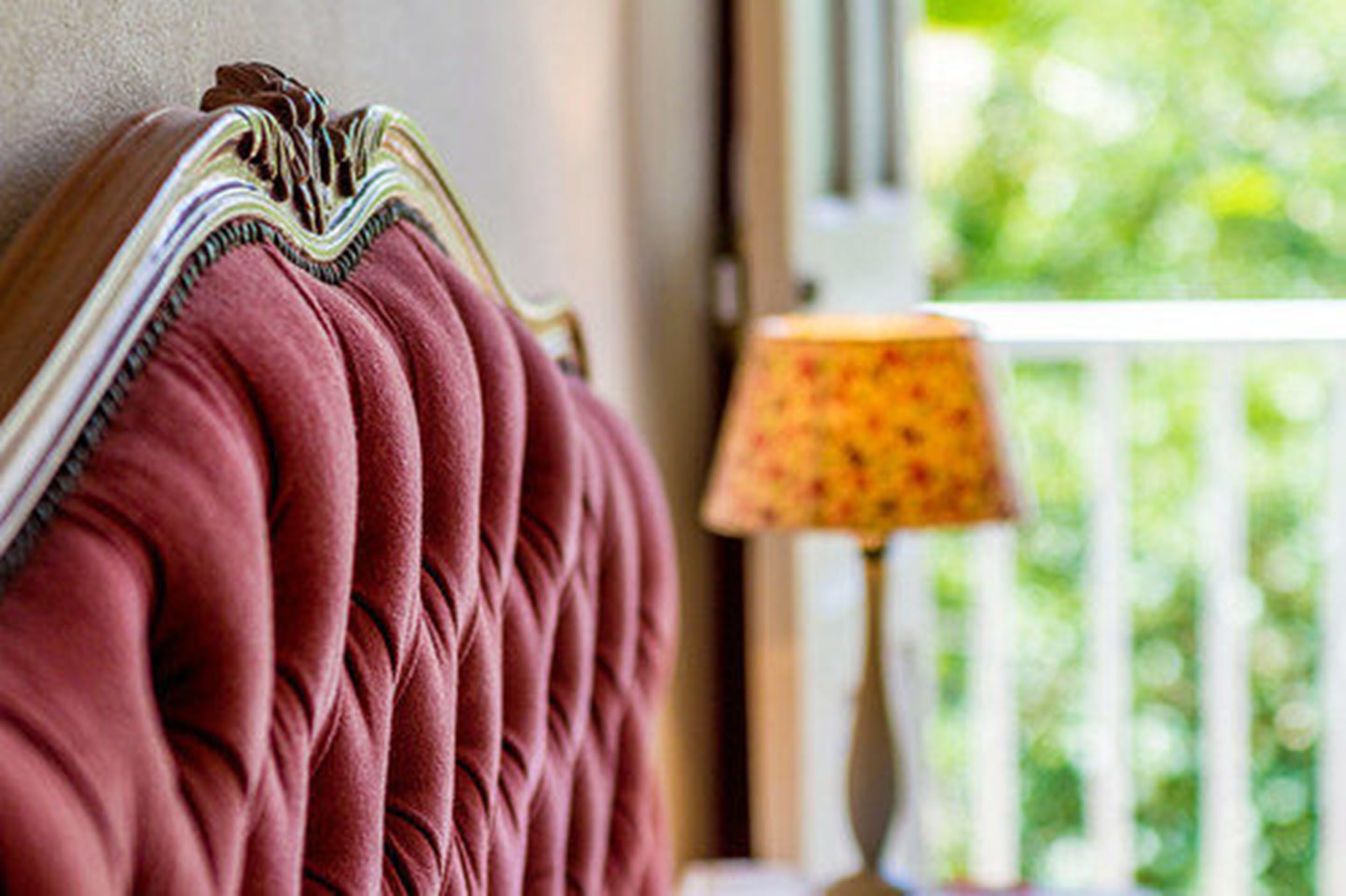 A close-up of a plush, tufted sofa with a decorative, striped cushion.