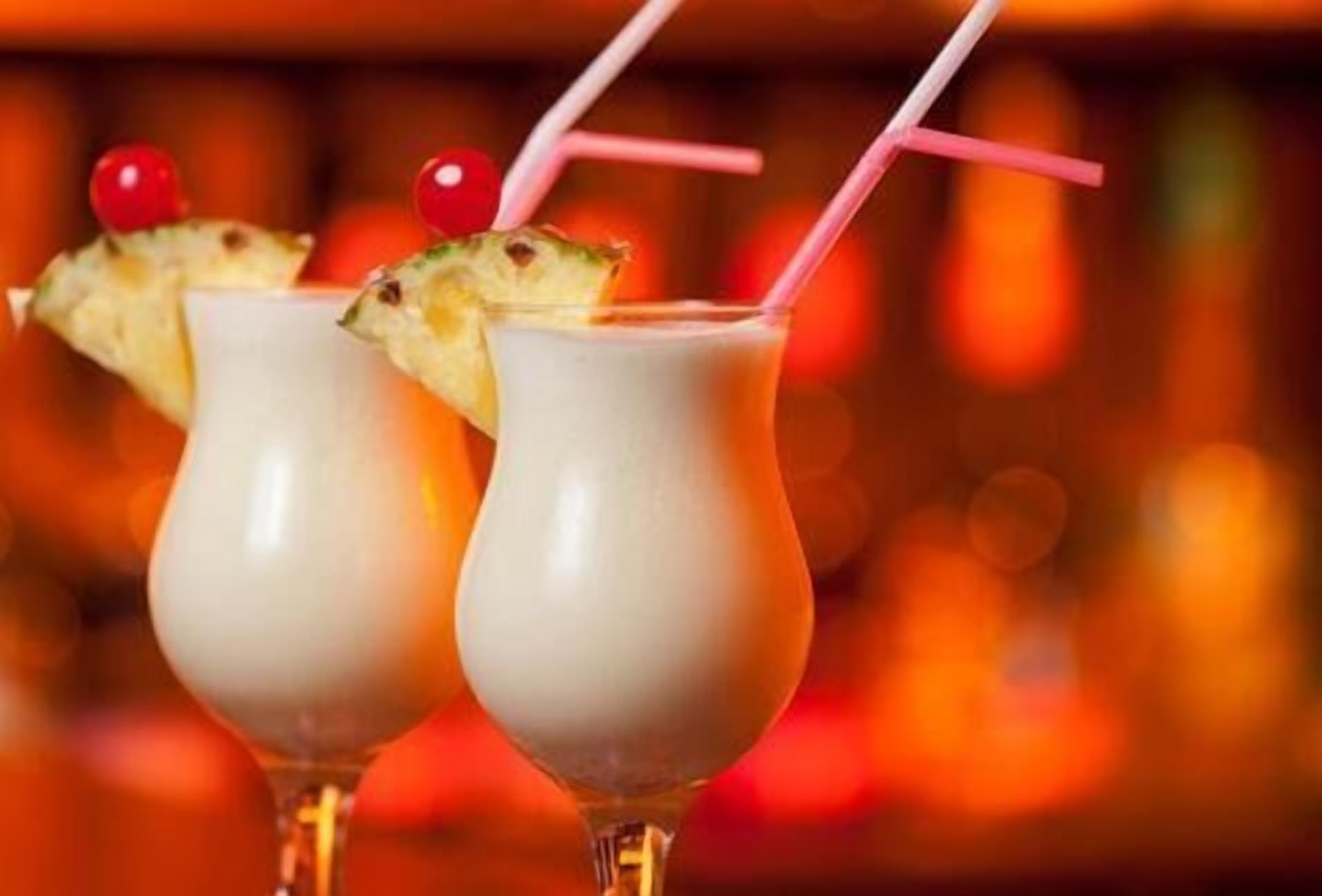 Zwei Cocktails mit Strohhalmen und Kirsche.