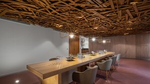 Una larga mesa de madera con sillas, un diseño de techo moderno y un interior minimalista.